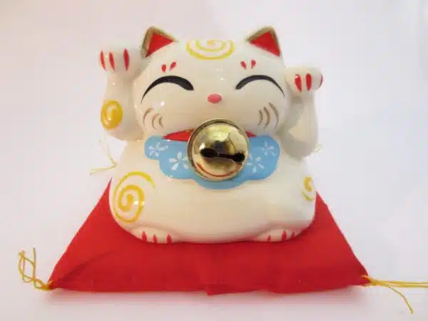 Lucky cat White with bell on red pillow A